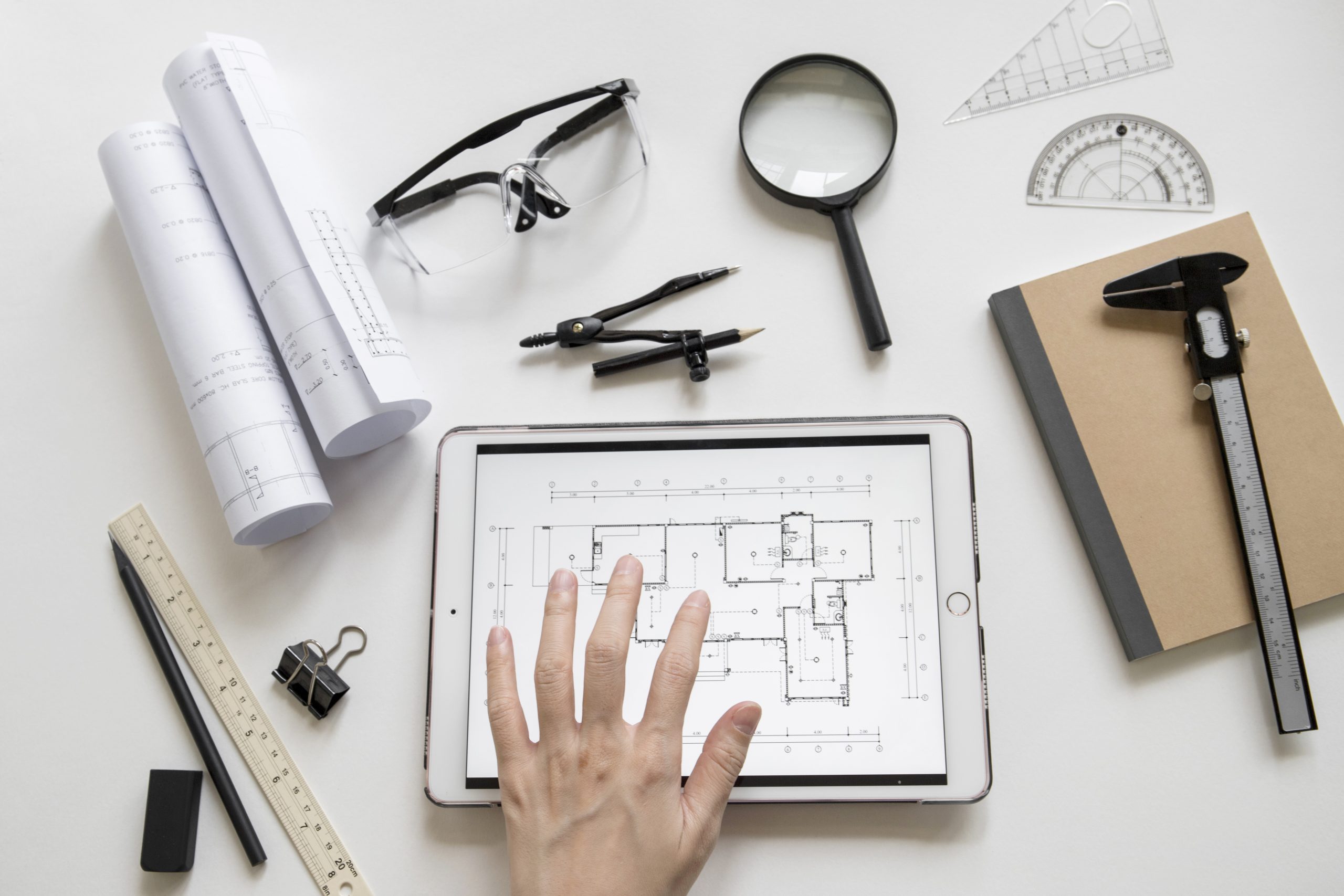 crop-hand-using-tablet-with-blueprint